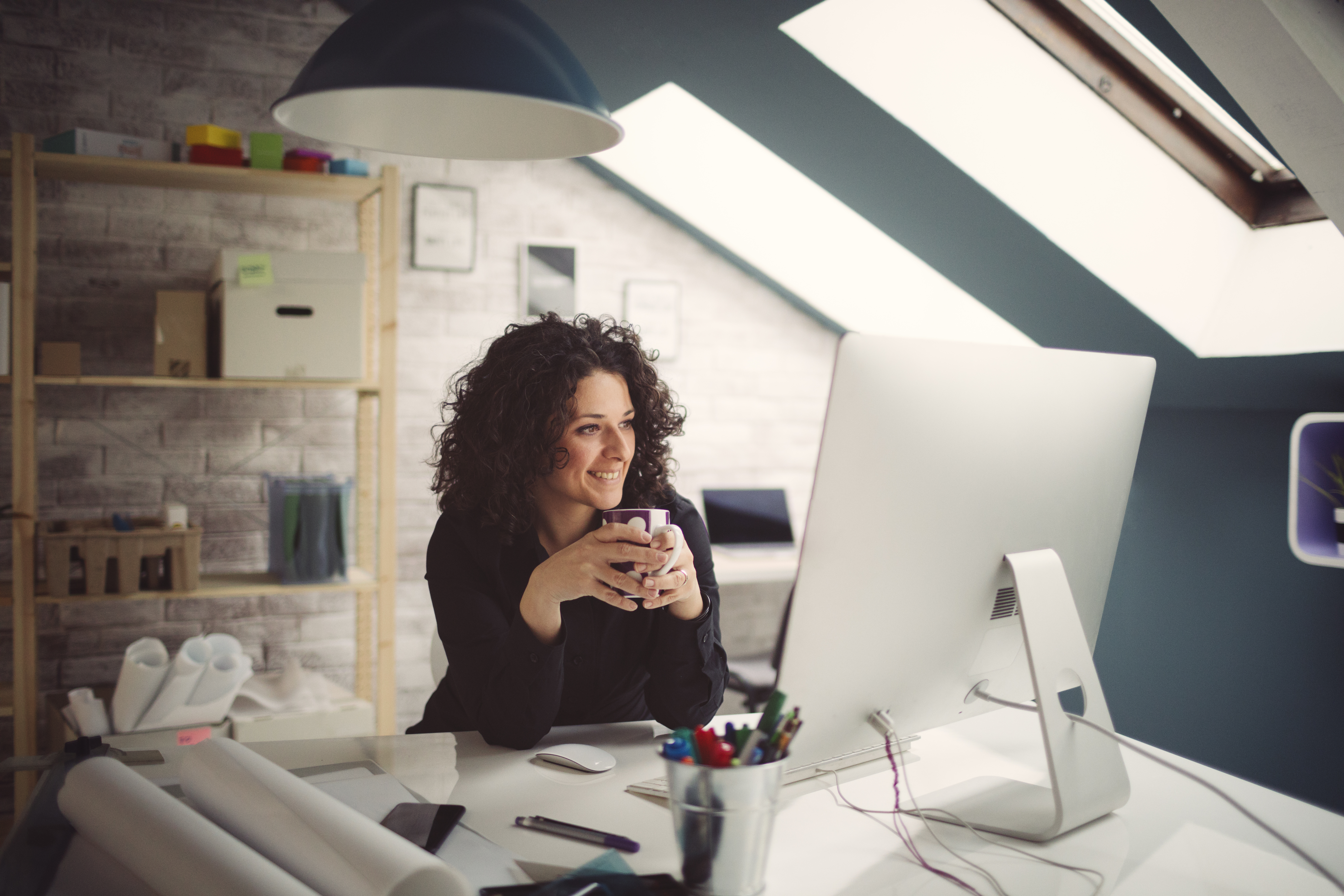 Woman enjoying a cup of coffee at work